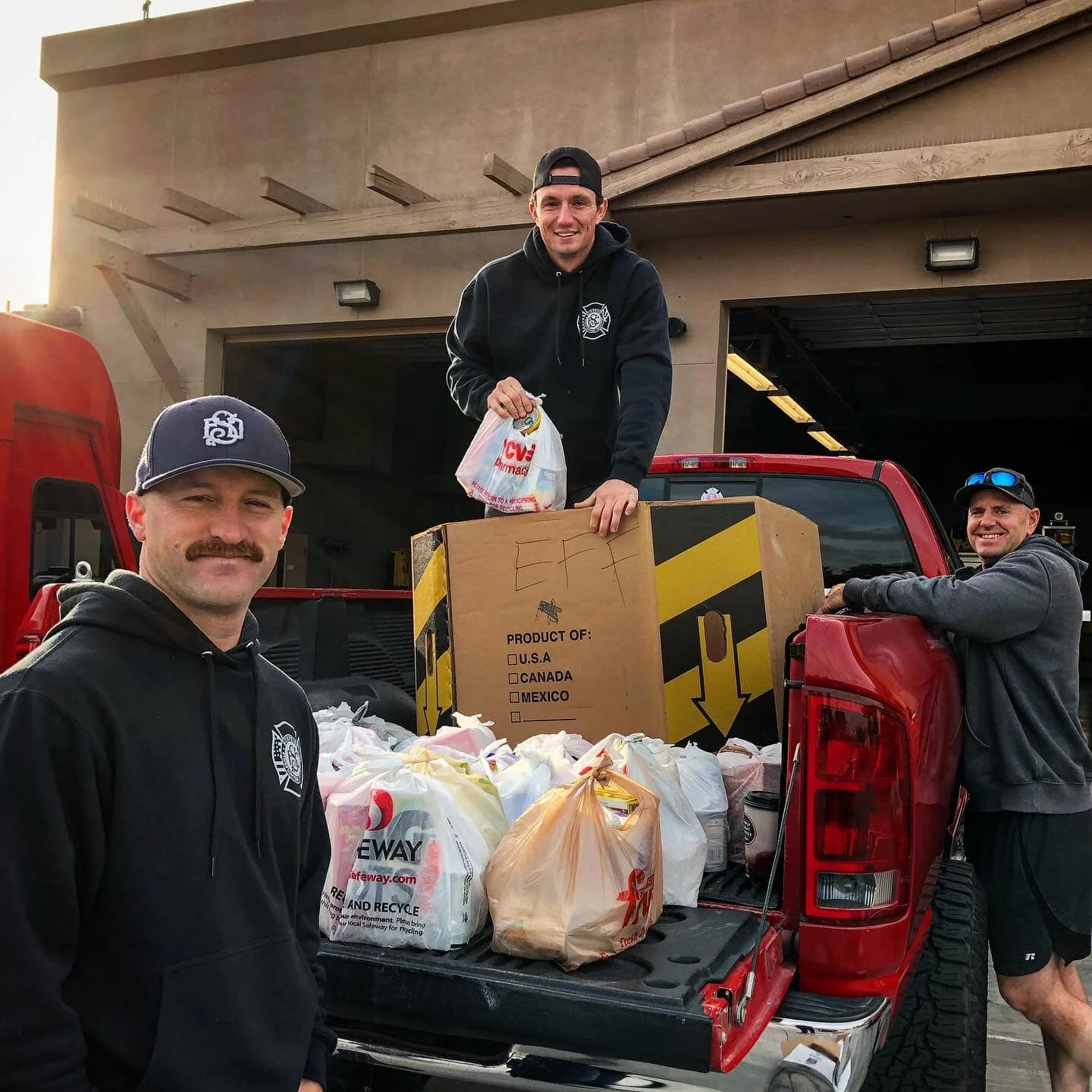 Firefighters loading donated groceries into a truck.